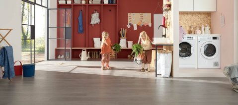 wineo 1000 PURLINE Bioboden Holzoptik Hauswirtschaftsraum HWR Kinder mit Gummistiefeln Möhren Waschmaschine 