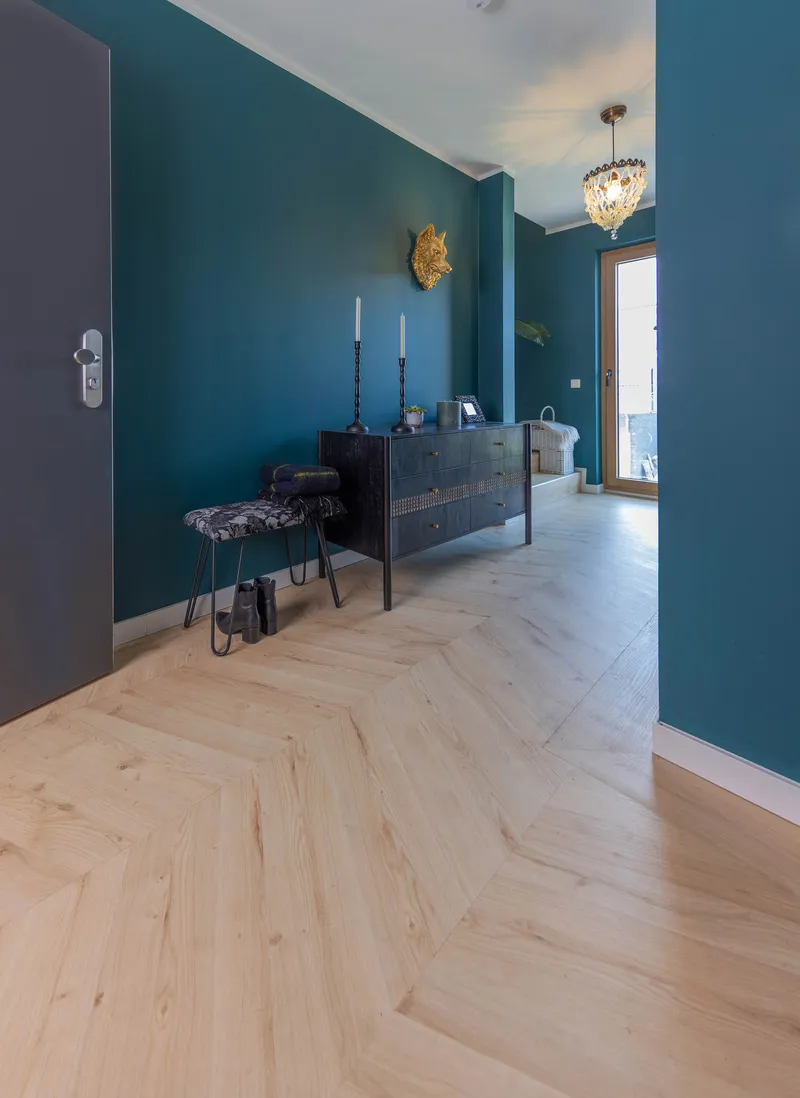 wineo PURLINE Bioboden wineo PURLINE Bioboden im Flur Holzoptik Fischgrätmuster Kommode blaue Wand