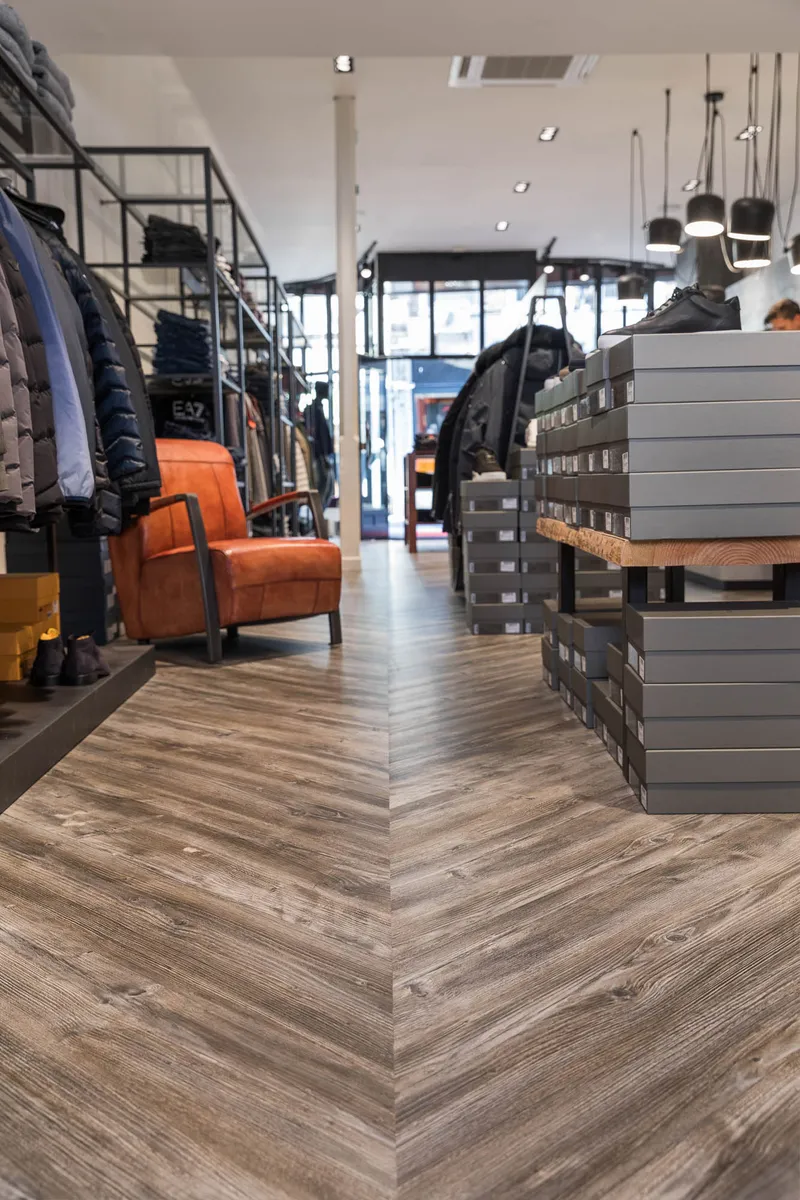 wineo Purline Bioboden wineo Purline Bioboden Holzoptik warm Fischgrätverlegung Sessel rot Modegeschäft