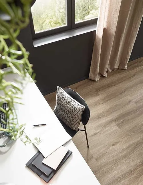 Schreibtisch mit Schreibtischstuhl auf einem modernen Vinylboden in Holzoptik